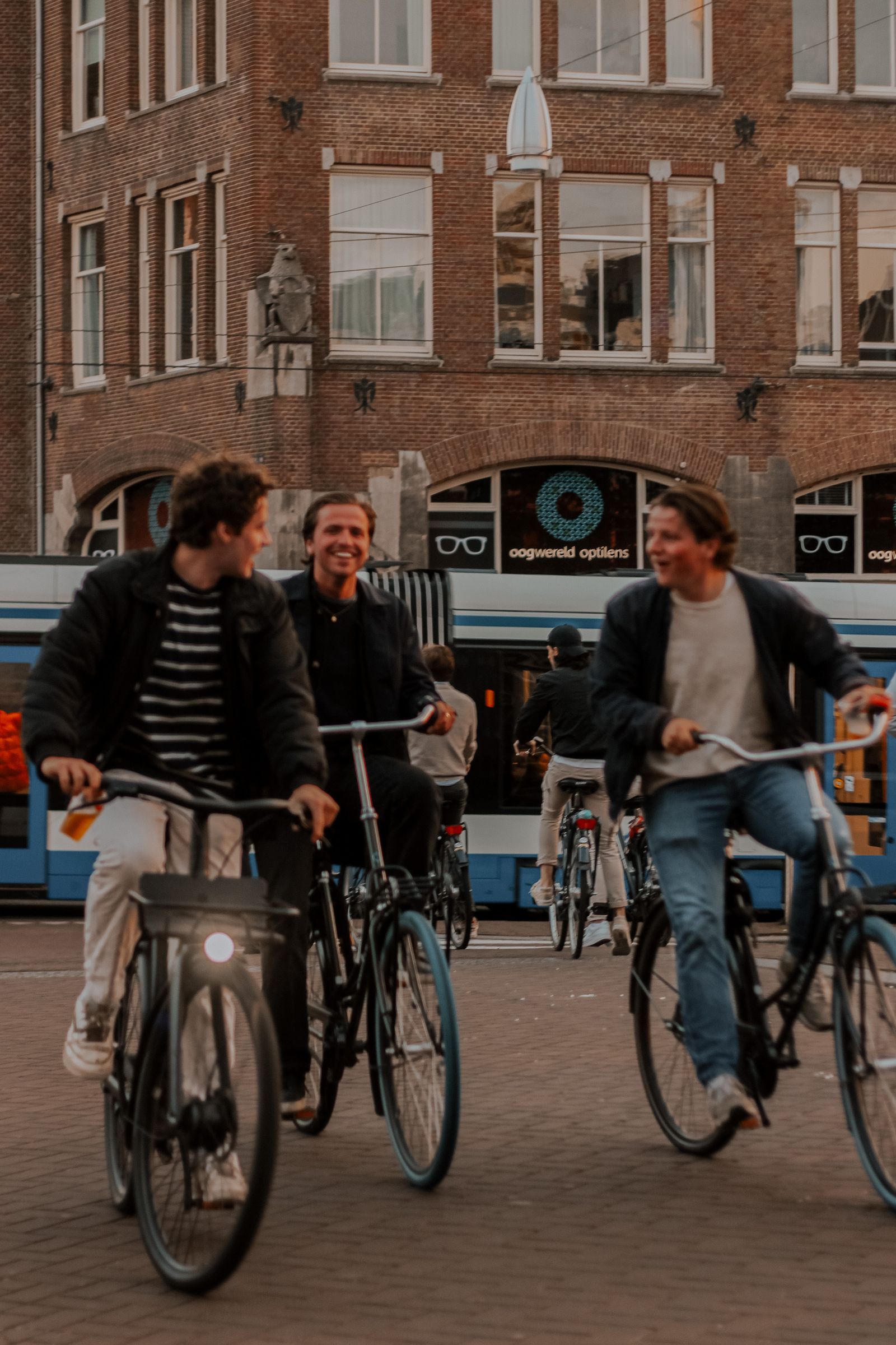 Friends cycling on an Amsterdam street, photographed by Sena Aykut